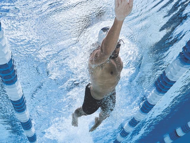 An underwater view of a male swimmer swimming laps at a Life Time pool