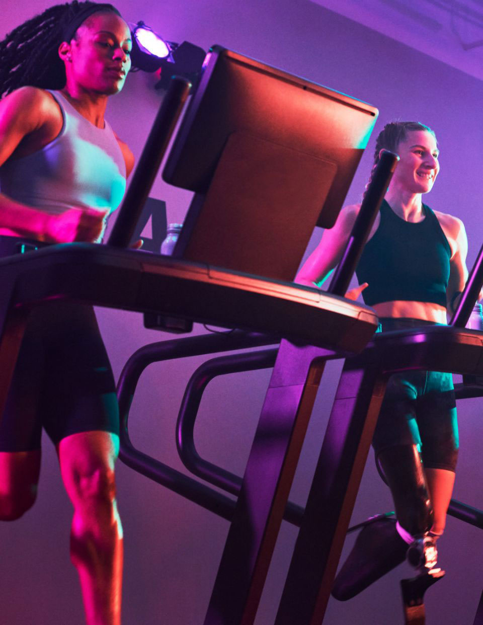 2 woman run on side by side treadmills