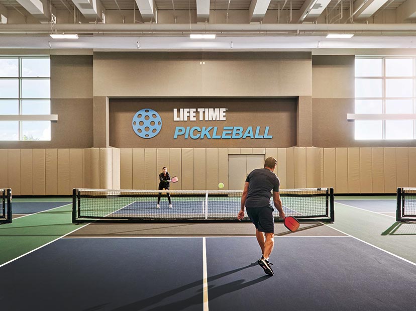 2 people play pickleball on an indoor pickleball court
