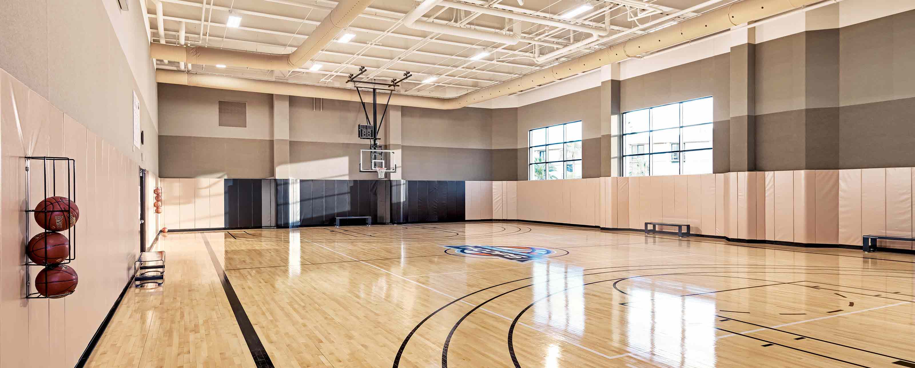a large gymnasium with basketball courts and basketballs
