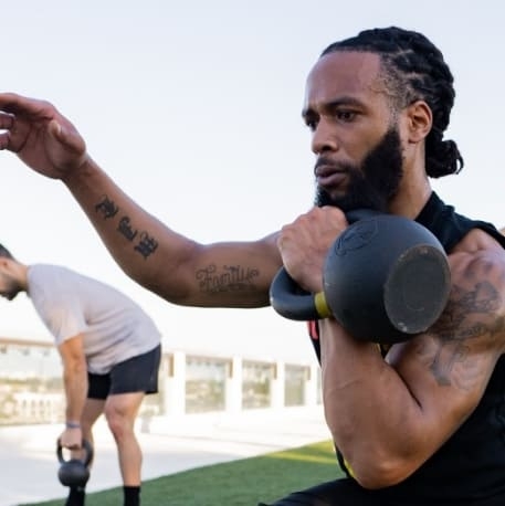 A male lifting a kettlebell.