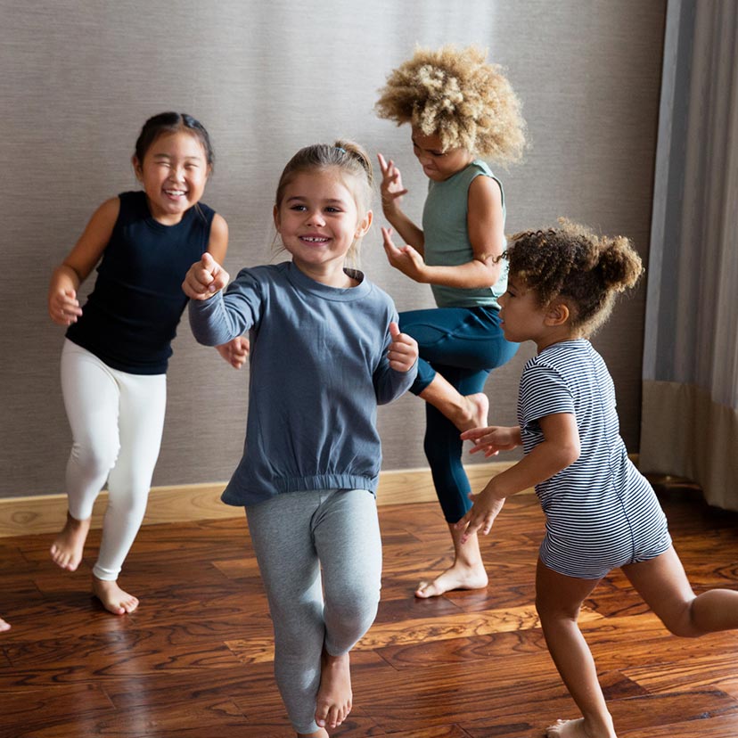 A group of kids run around and dance in a studio
