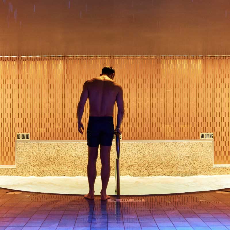 A man stands outside a hot tub
