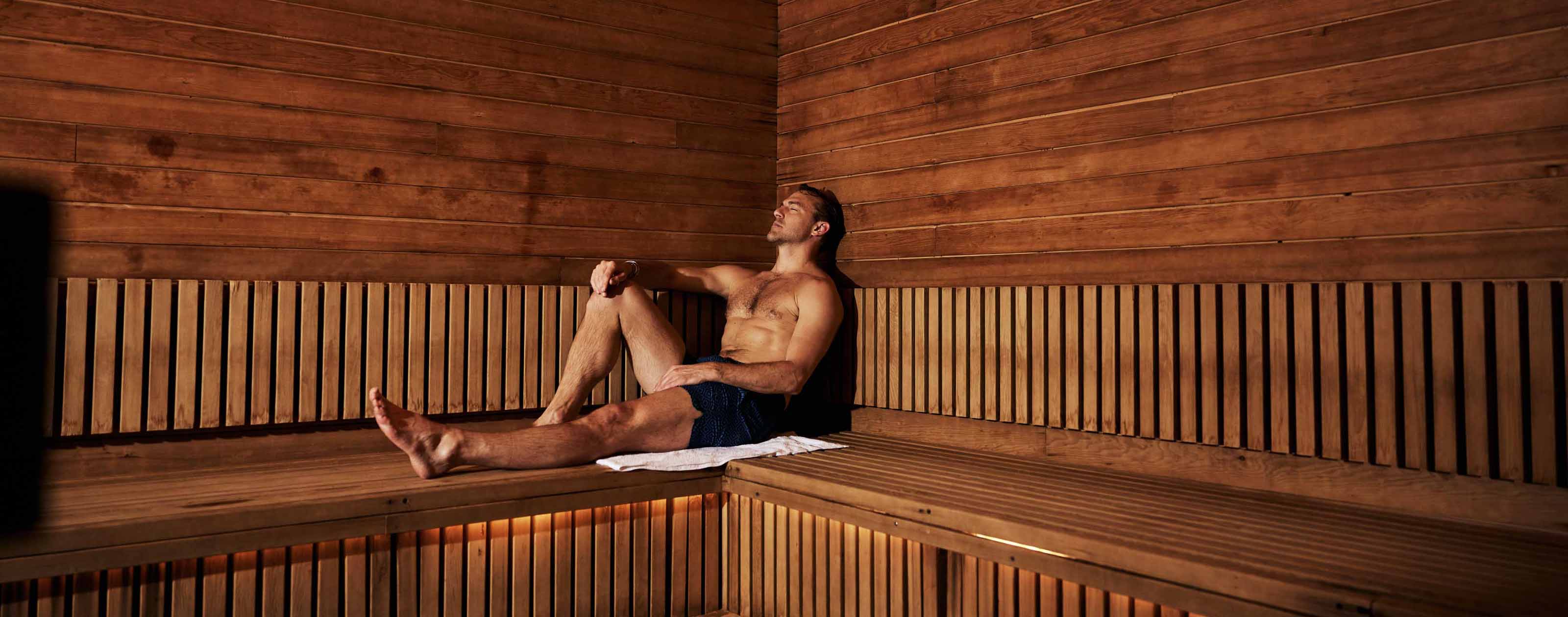 a man relaxes in a wood sauna