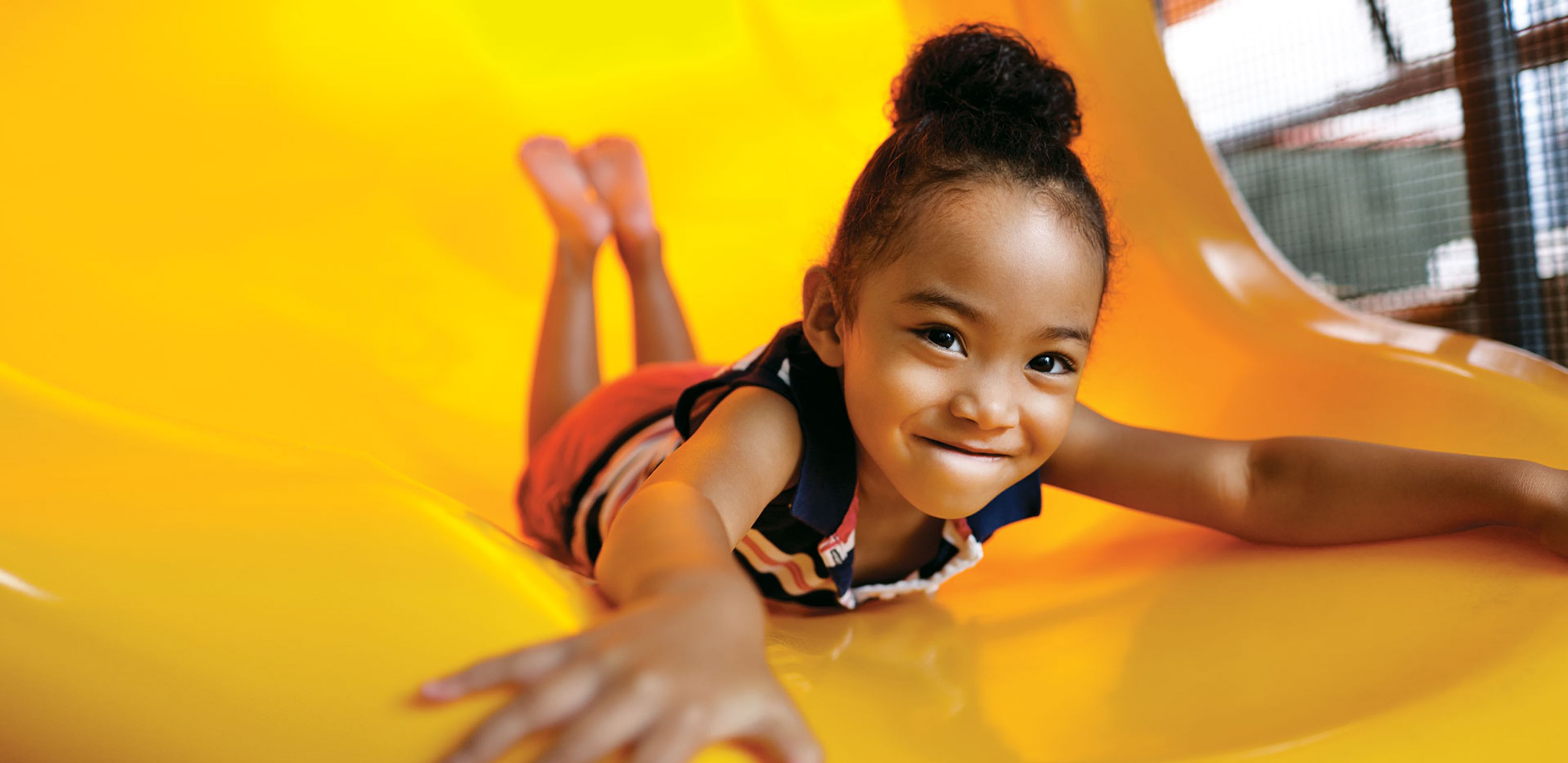 a small girl sliding down a slide