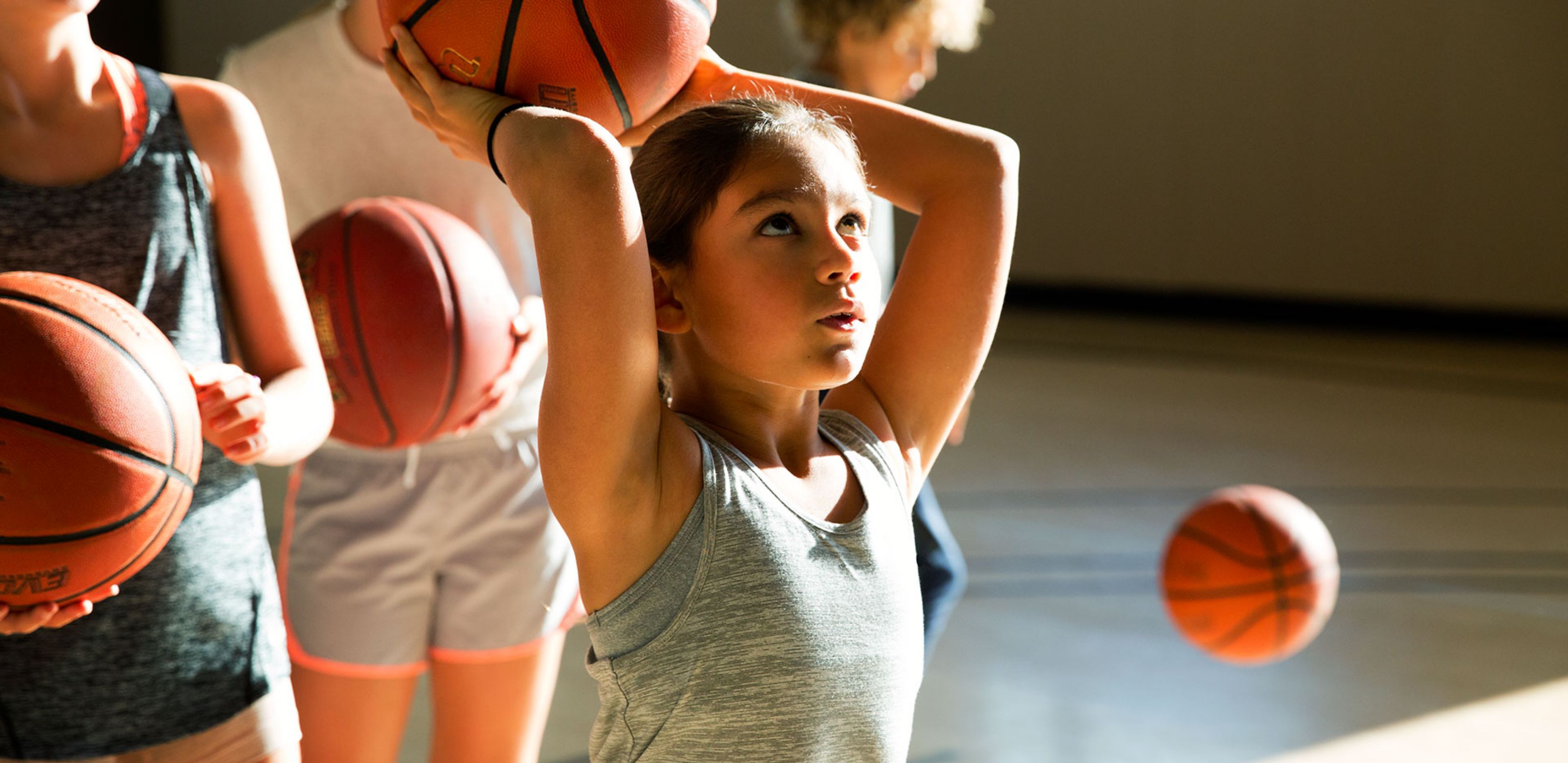 a girl raising a basketball over her head