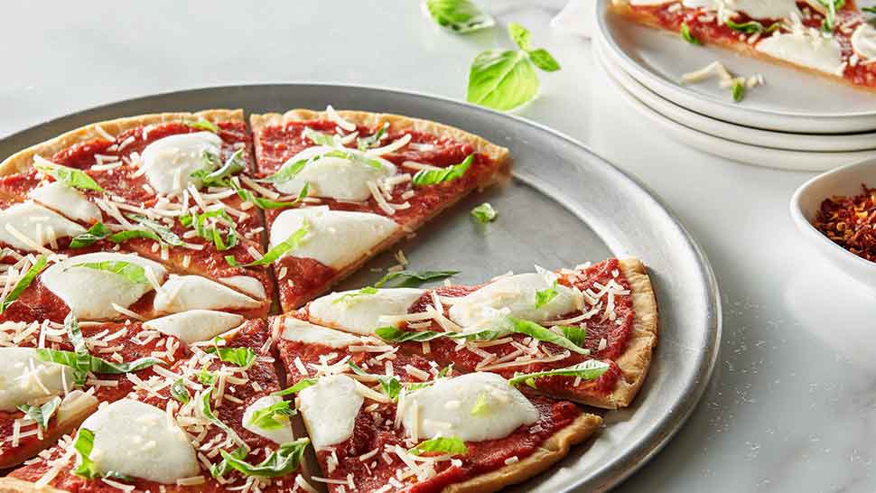 Margherita pizza featuring fresh basil and mozzarella on a Caulipower crust