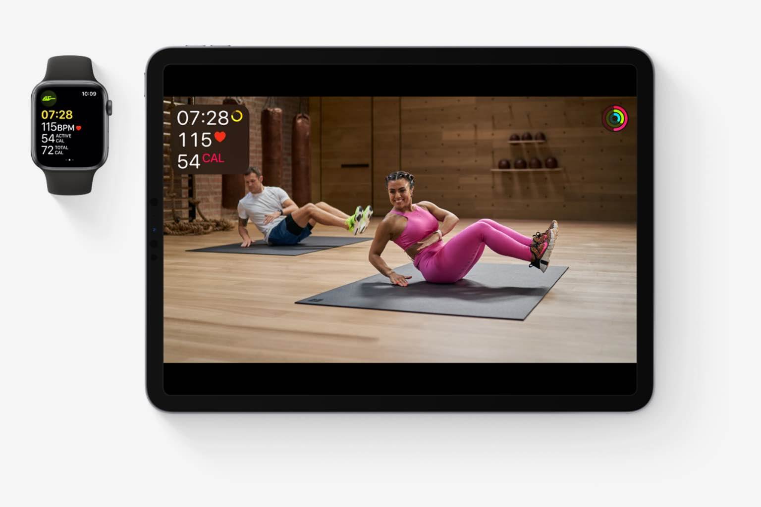 iPad and apple watch with Apple Fitness+ video classes and metrics on the screen. 