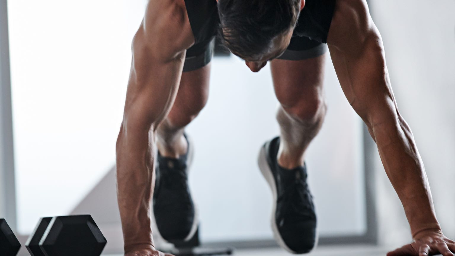 Man does burpees during his at home workout with Life Time Classes On Demand