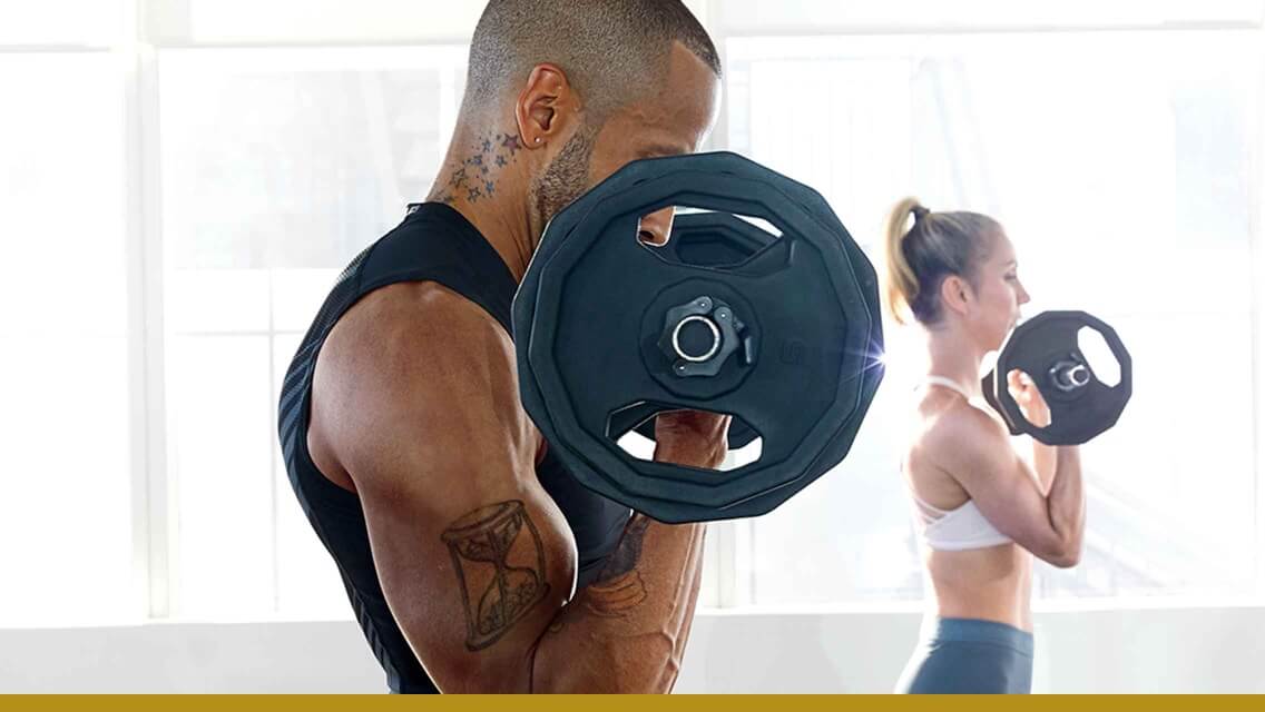 A man and woman curling barbells