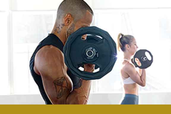 A man and woman curling barbells