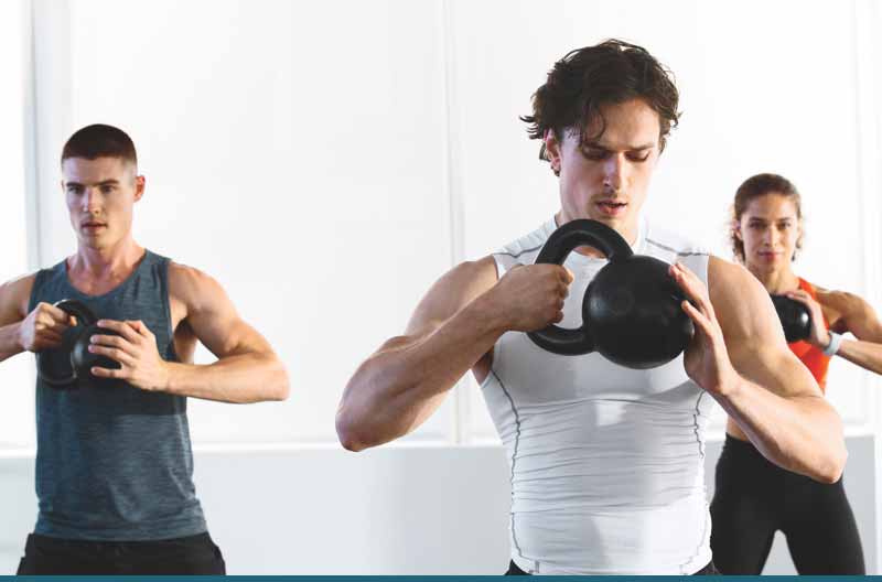 A man and woman lifting kettlebells