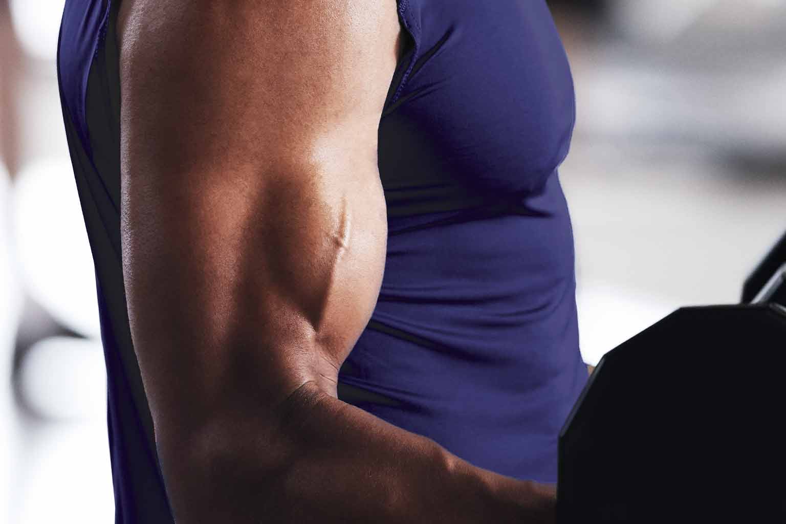 A man curling a barbell with his bicep flexing in the process.